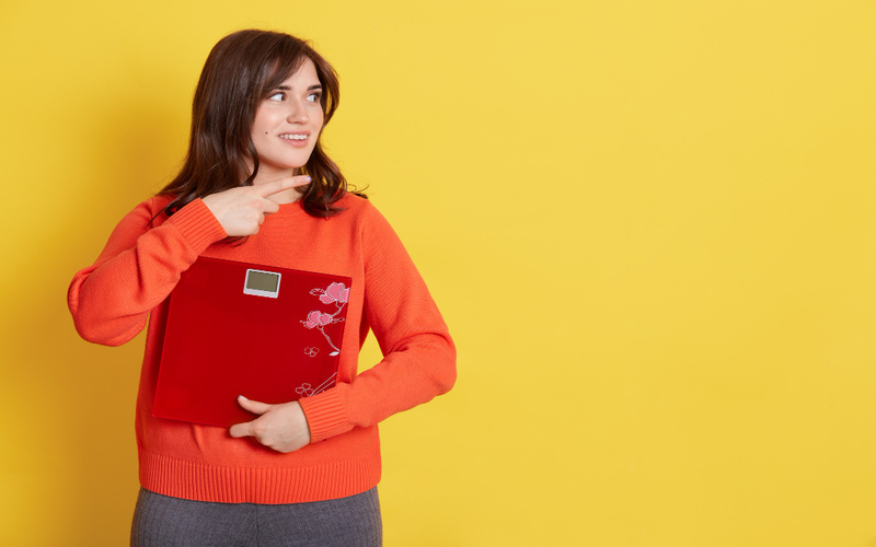 women holding a floor weighing scale